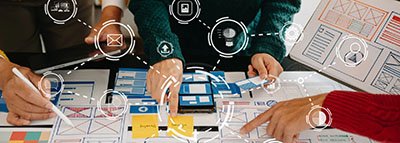 collaborative UX designers working at a table with website layout designs